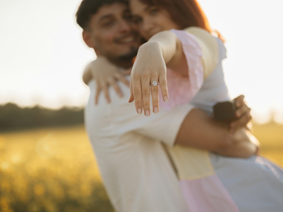 Close-up of an engagement ring on a partner’s hand during an outdoor engagement photoshoot.