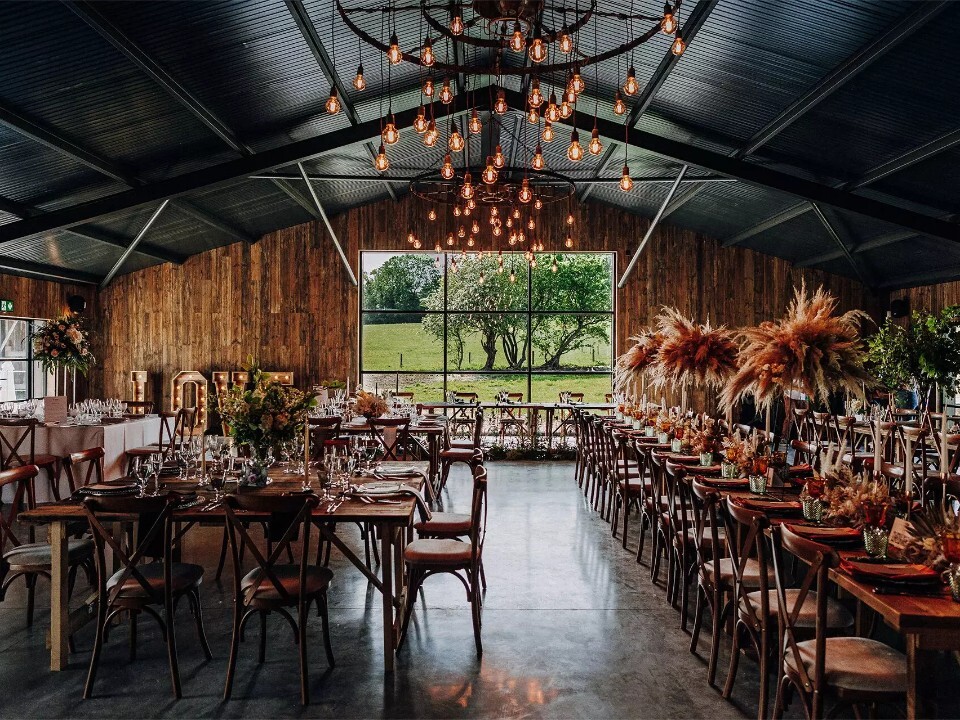 Interior of modern wedding barn set for wedding breakfast. The venue is Silchester Farm in Hampshire.