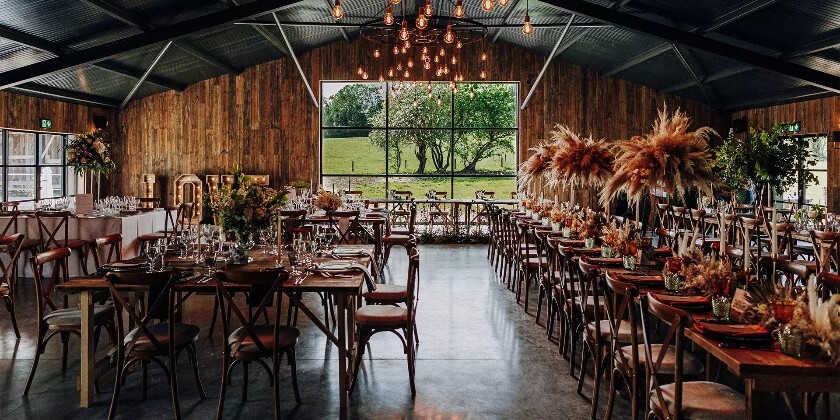 Interior of modern wedding barn set for wedding breakfast. The venue is Silchester Farm in Hampshire.