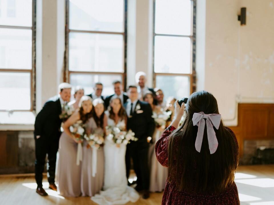 wedding photographer capturing group photo of wedding party