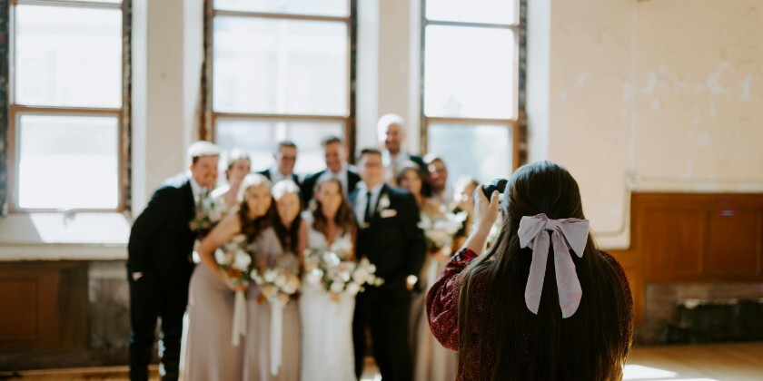 wedding photographer capturing group photo of wedding party