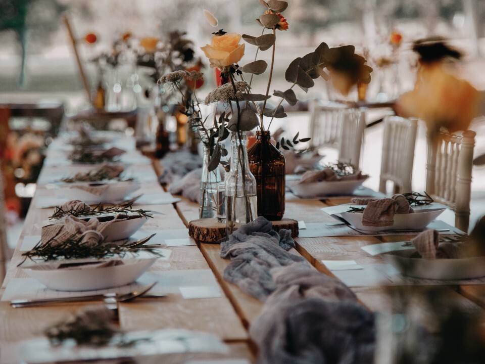 Long banquet-style wedding table set for a relaxed shared dining wedding reception.
