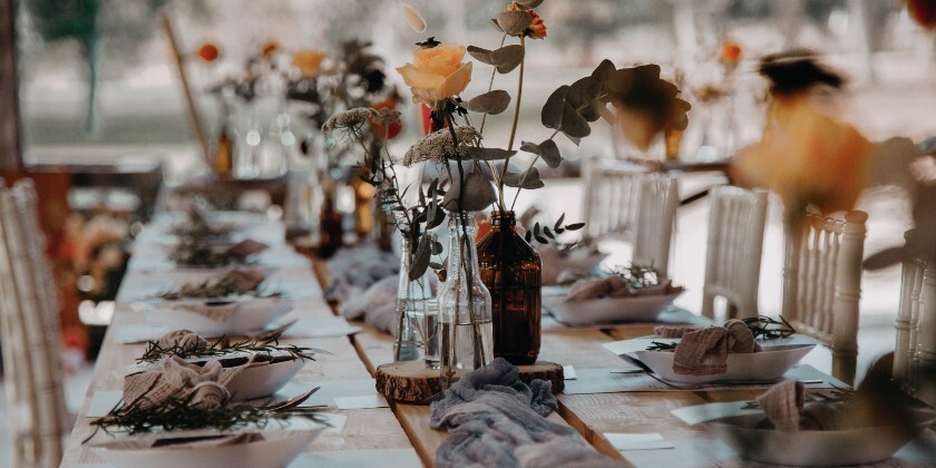 Long banquet-style wedding table set for a relaxed shared dining wedding reception.
