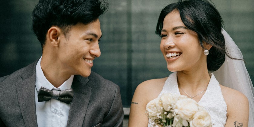 Bride and groom looking at each other and holding hands