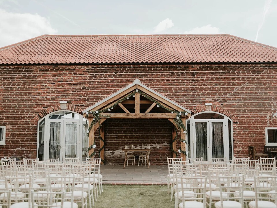 Exterior of Barn venue in daylight with ceremony area