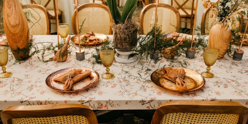Sustainable wedding tablescape with reusable décor, vintage-style glassware, hired tableware, candles and natural floral styling at a wedding reception.