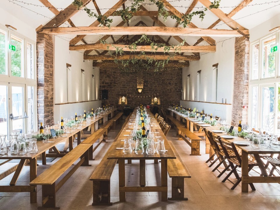 Benches set up for wedding dinner in barn venue