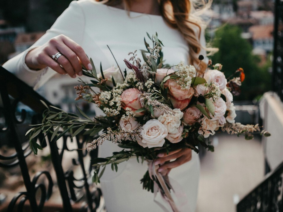 Bride holding a wedding bouquet with pink, white and green flowers