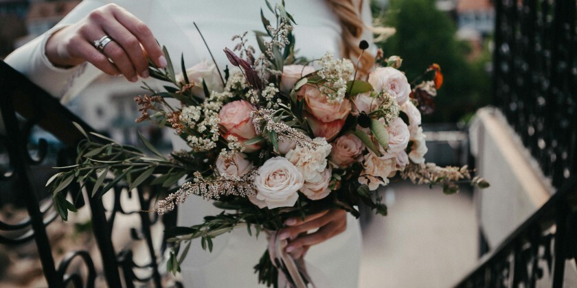 Bride holding a wedding bouquet with pink, white and green flowers