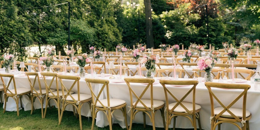 Tables set for an outdoor wedding with alfresco dining.