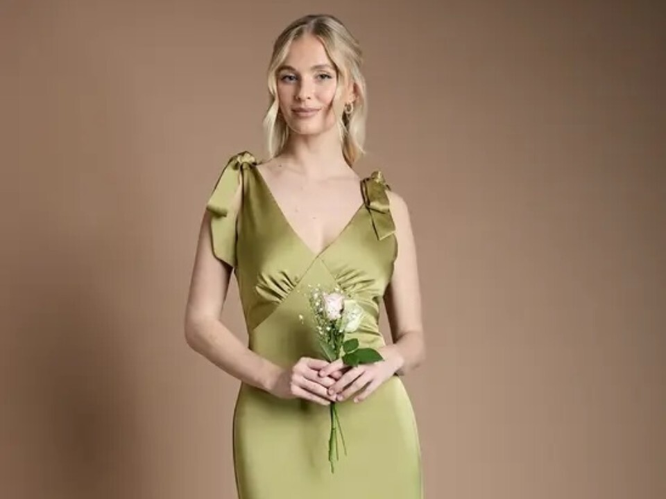 Teen bridesmaid wearing an olive green satin maxi bridesmaid dress with tie shoulder straps and a V-neckline.