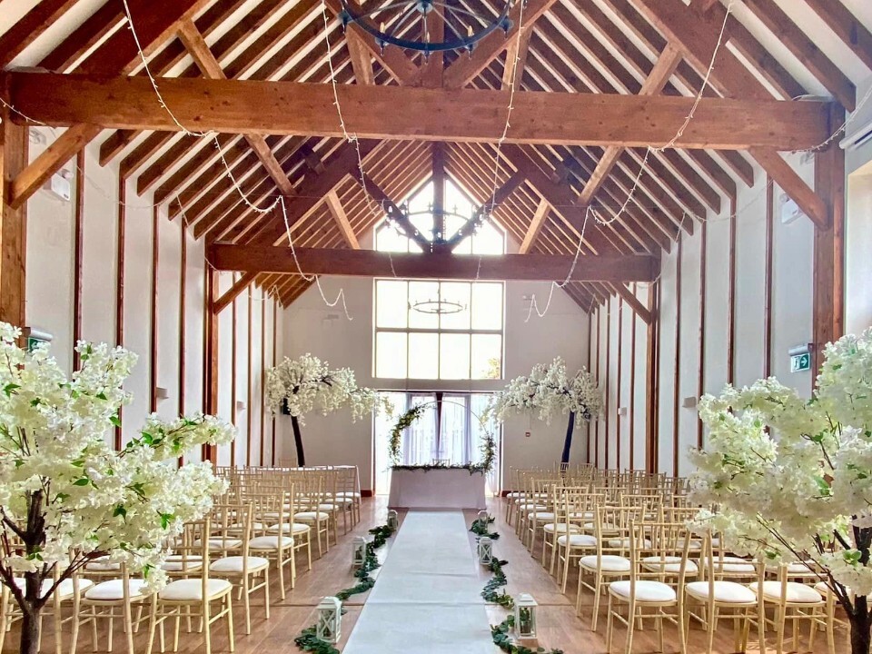 barn wedding ceremony with light interior and wooden beams