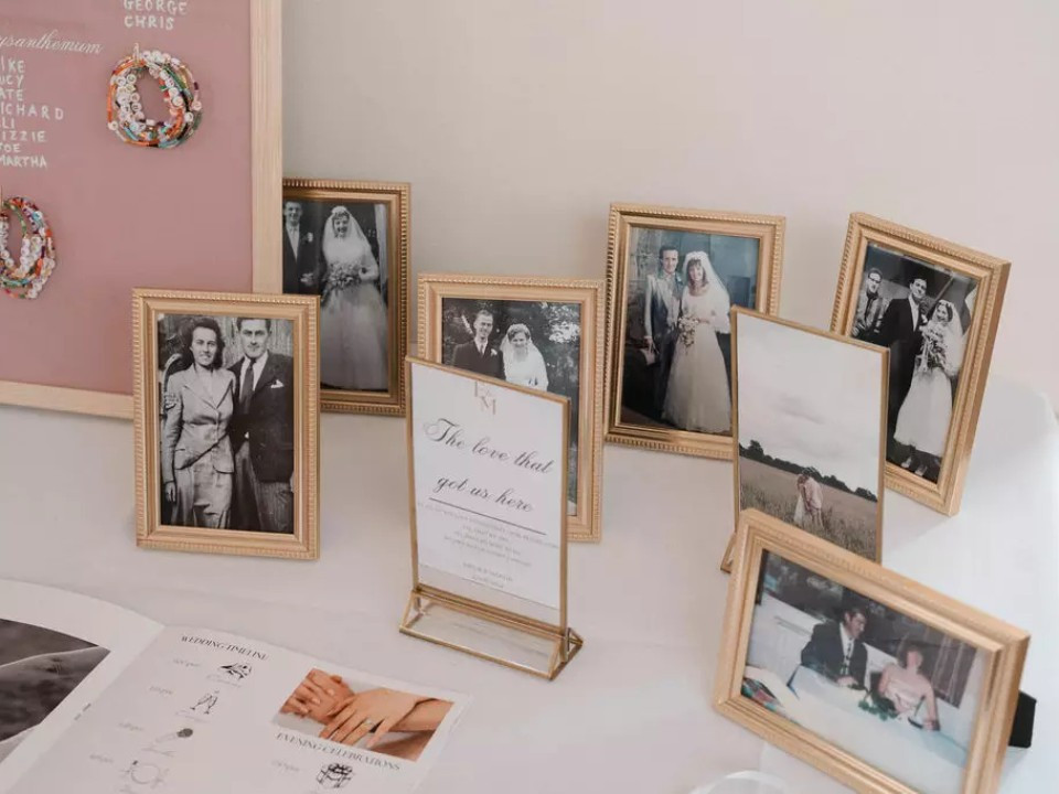 Wedding memory table displaying framed photographs of loved ones who have passed away.