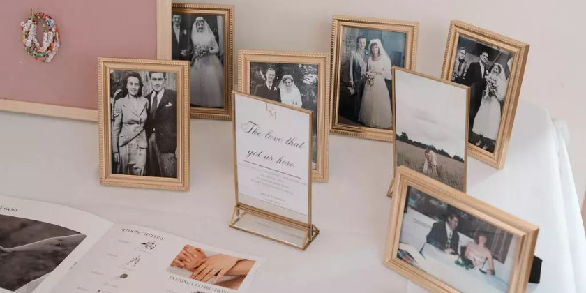 Wedding memory table displaying framed photographs of loved ones who have passed away.