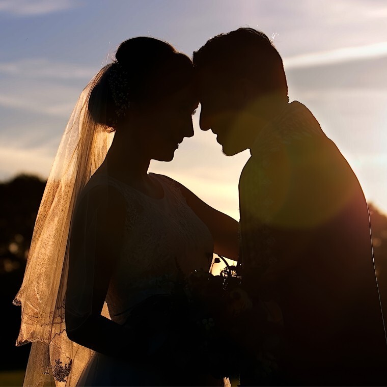 bride and groom kissing in silhouette at Northbrook park