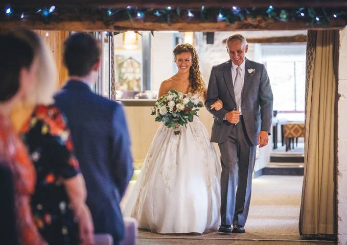 Bride enters wedding ceremony escorted by her father