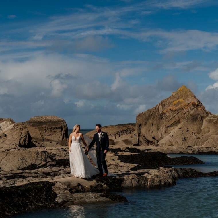 bride and groom walking along beach during couples photographs