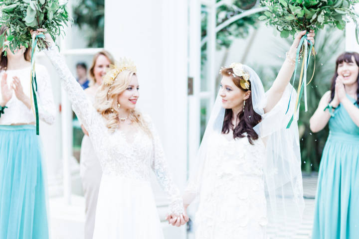 Brides cheering after wedding at the orangery, Gunnersbury Park