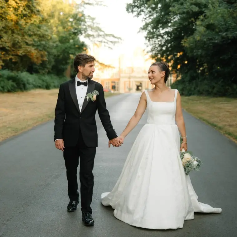 Married couple walking in front of wedding videographer
