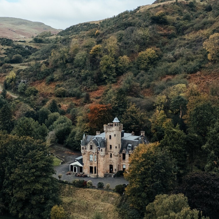 Drone image of broomhall castle with autumnal colours in the surrounding landscape