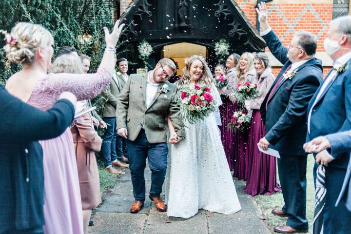 Bride and groom behind showered in confetti after Berkshire church wedding