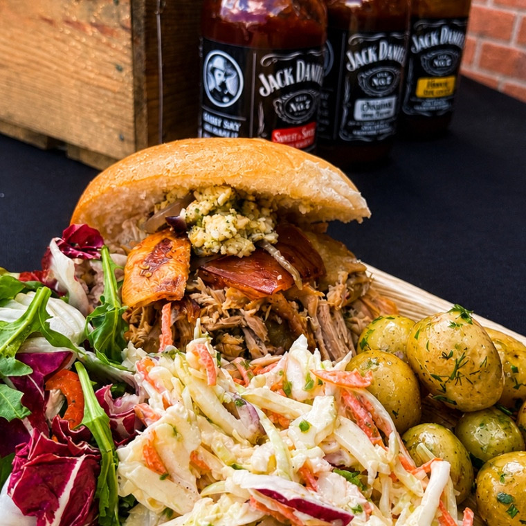 Hog roast sandwich with homemade coleslaw, potatoes and salad