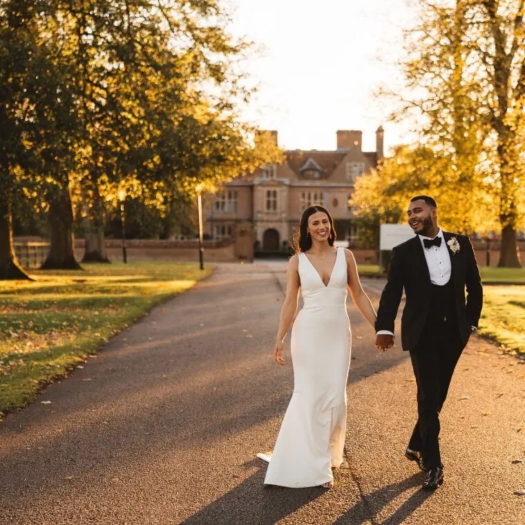 Couple walking down the sweeping driveway of Horwood House Wedding Venue