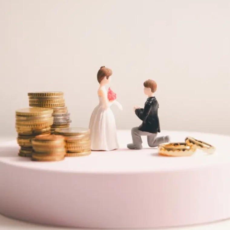 Models of bride and groom surrounded by coins and rings