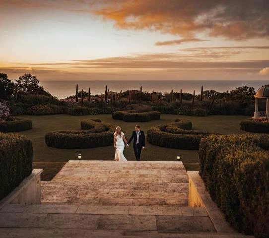Bride and groom walking up stairs with beautiful view