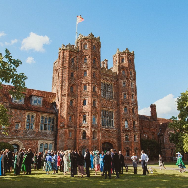 Exterior of Layer Marney Tower with wedding guests enjoying a drinks reception in the foreground