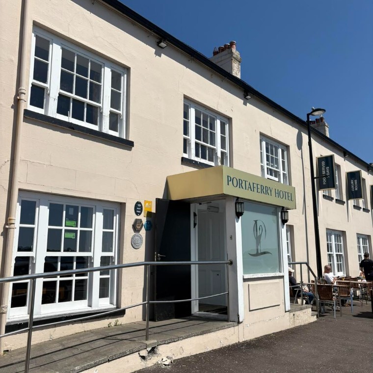 The Portaferry Hotel entrance with railing and lots of windows.
