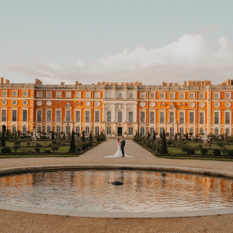 Bride and groom embracing gently, dressed in elegant wedding attire. Ideal for wedding planning inspiration at Hampton Court Palace.