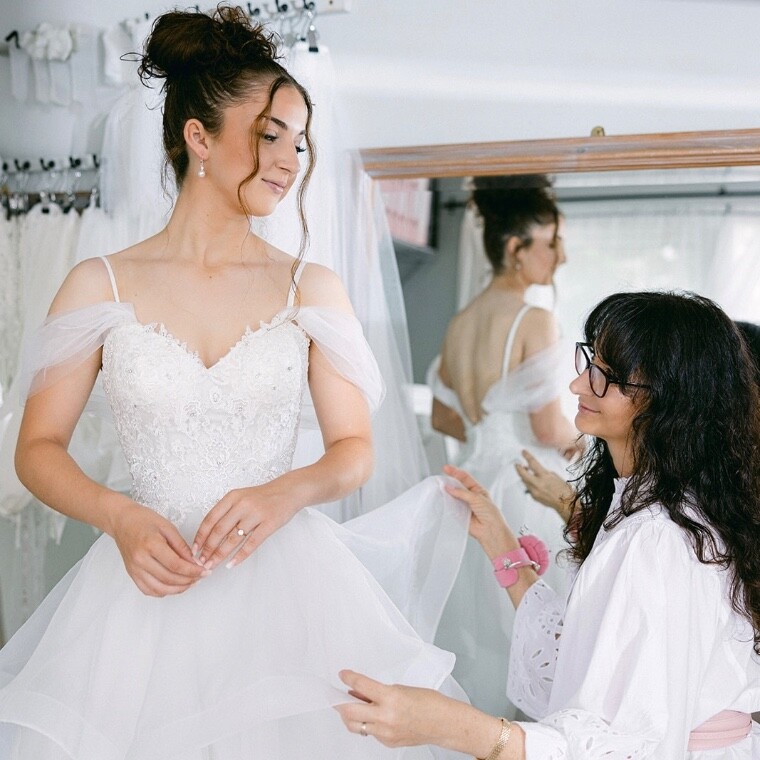 Luxury bridal seamstress adjusting a wedding dress during a fitting in Somerset studio