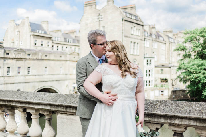 Bride and groom embrace on Pulteney Bridge, Bath
