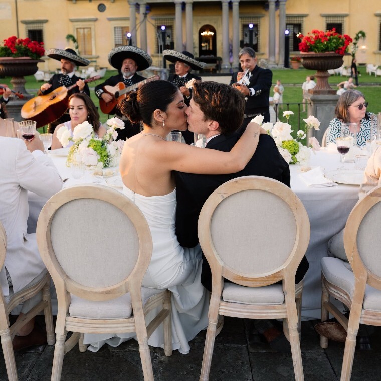 Bride and groom sharing a kiss during an outdoor wedding reception at an Italian villa, photographed by Buckinghamshire wedding videographer Gaetano Di Giacomo.