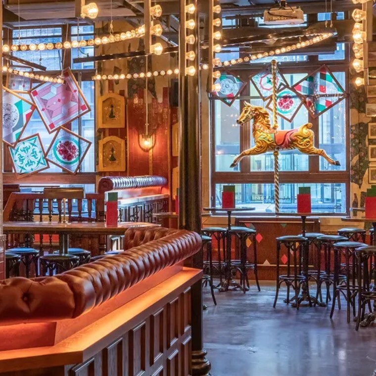 carousel horse in a fairground themed bar with stained glass windows