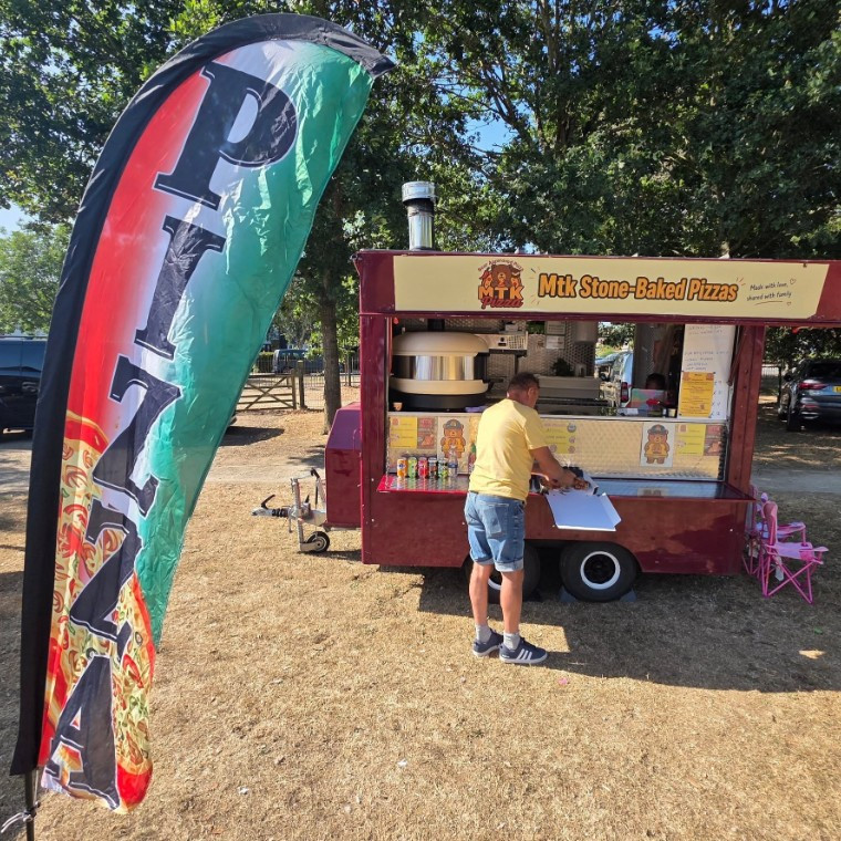 Mobile pizza catering trailer serving freshly stone-baked pizzas at weddings and events
