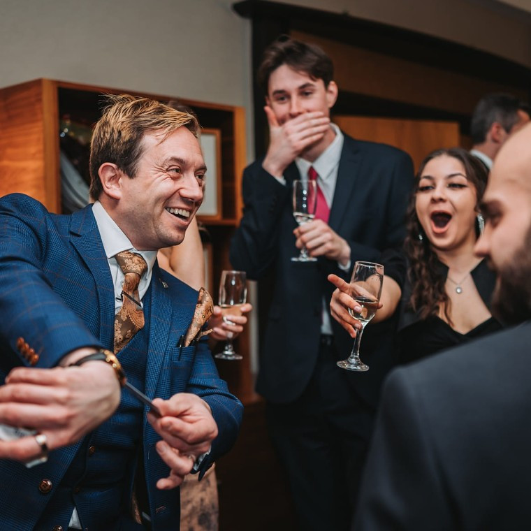 Matthew Garrett performing close-up wedding magic as guests react with amazement