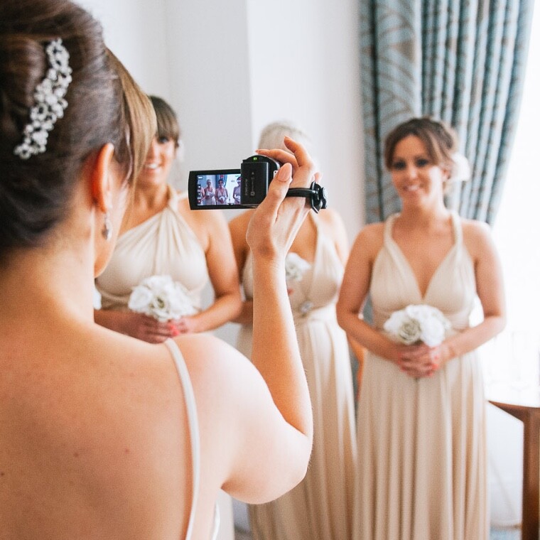 Bride filming her bridesmaids on her wedding day