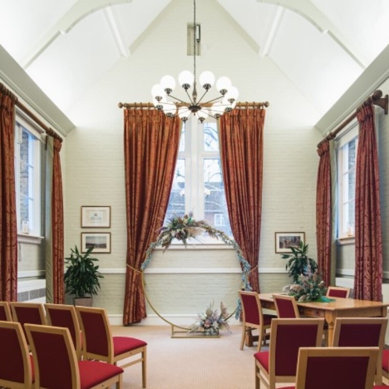 Light and airy room with vaulted ceilings, a beautiful chandelier and rich orange/red accents in the soft furnishings.