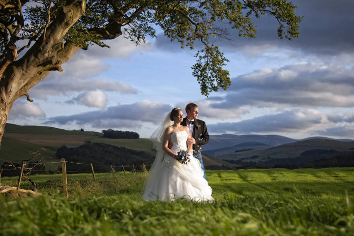 Bride and groom in field with gorgeous view