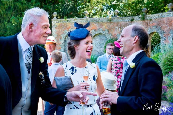 Wedding guests giggling Hampden House in Buckinghamshire