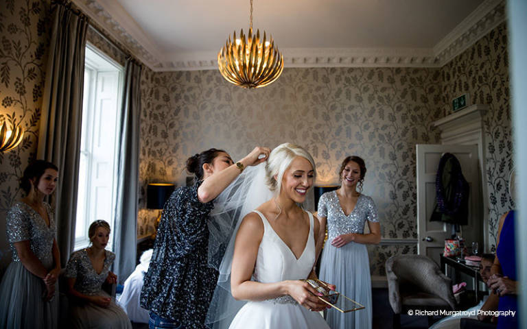 A bride gets ready with her bridesmaids in the Cherry suite at Morden Hall in London