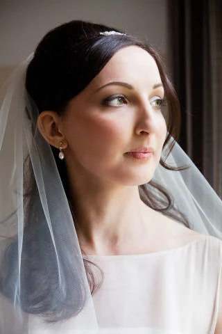 Bride with veil looking out of the window