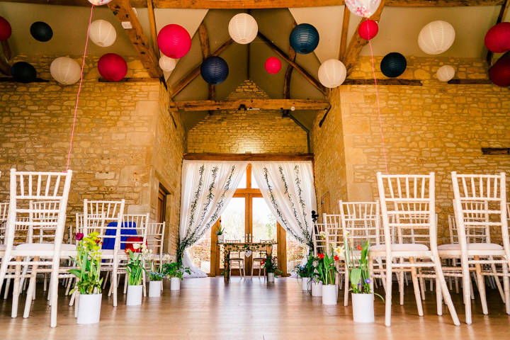 Colourful wedding ceremony inside The Barn at Upcote