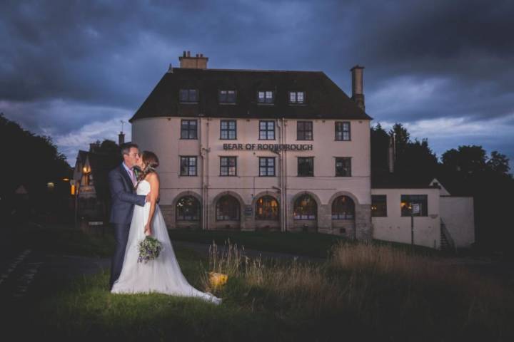 Couple kissing at night outside The Bear of Rodborough Hotel