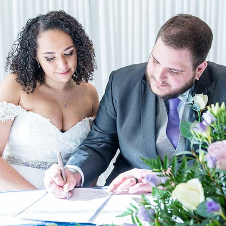 Brde and Groom signing the marriage certificate at Chichester Harbour Hotel
