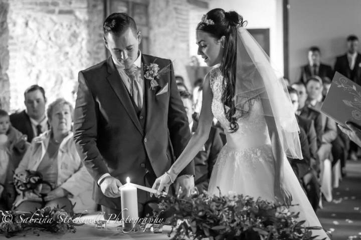 Unity candle lighting. Wedding ceremony Westenhanger castle photography by Sabrina Stockwell