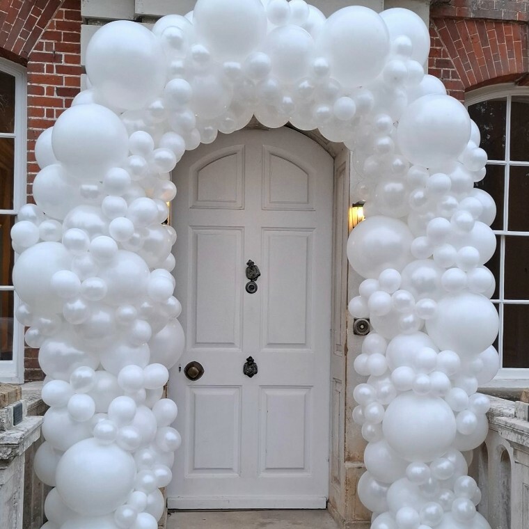 White balloon arch around the main door at Ardington House wedding venue, Oxfordshire