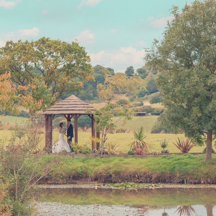 Bride and groom stealing a moment of quiet in a beautiful garden under a canopy.
